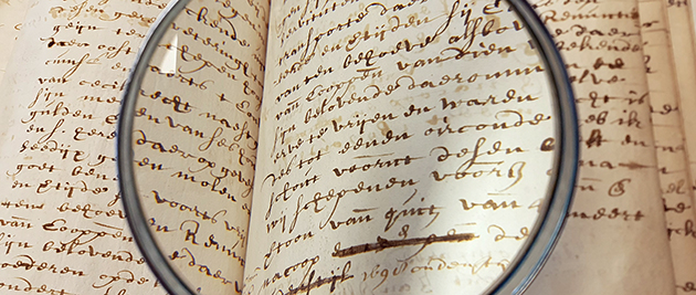 Deze afbeelding toont een loep boven een oud handschrift. 